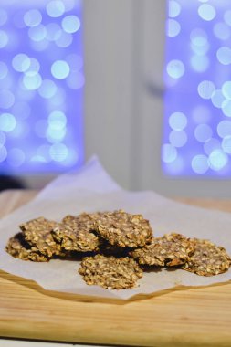 Sağlıklı şekersiz ve un ücretsiz muz ve festival arka ışıkları ile ahşap bir gemide yulaf ezmeli kurabiye.