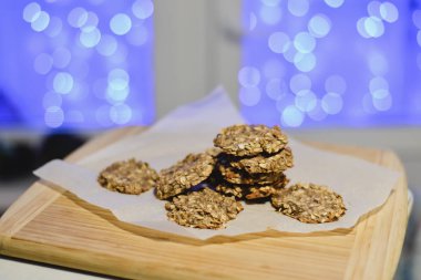 Sağlıklı şekersiz ve un ücretsiz muz ve festival arka ışıkları ile ahşap bir gemide yulaf ezmeli kurabiye.
