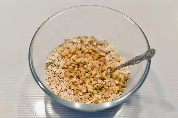 Ingredientes para un pastel saludable sin azúcar y sin harina: avena con nueces en un recipiente de vidrio . — Foto de Stock