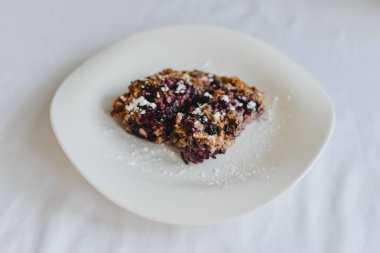 Ücretsiz muz yulaf ezmesi kek çilek gri bir tableclothe üzerinde beyaz bir tabakta ile sağlıklı şekersiz ve un.