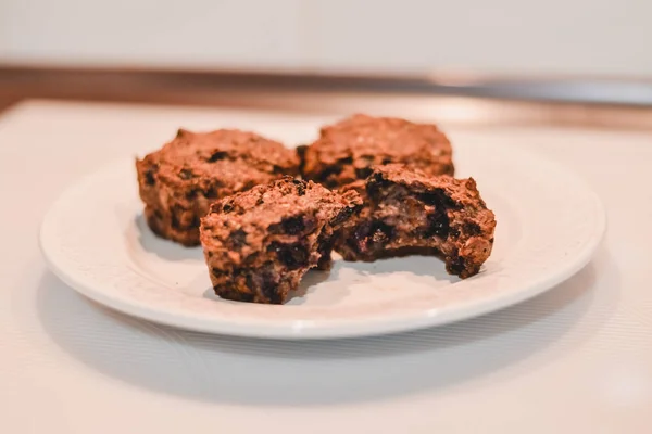 Muffins saludables sin azúcar y sin harina de avena de plátano con arándanos en un plato blanco sobre un mantel gris . —  Fotos de Stock