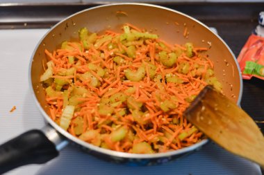 Bir Asya yemek yapmak bir süreçtir: havuç ile dilimlenmiş kereviz derin tavada kızarmış.