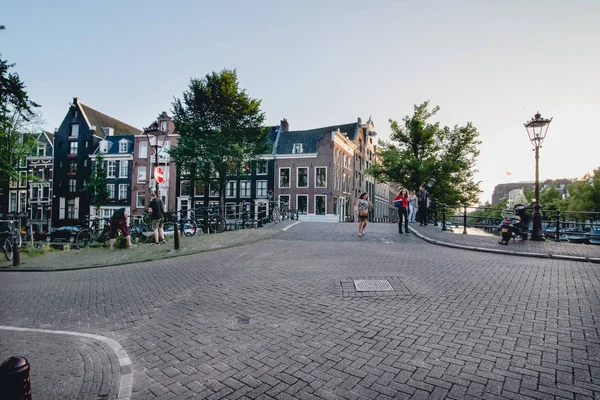 Amsterdam - ca. juni 2017: klassischer blick auf kanal und brücke mit traditionellen holländischen häusern auf den böschungen in amsterdam, Niederlande im juni 2017. — Stockfoto