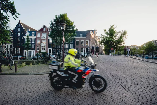AMSTERDAM - CIRCA JUNIO 2017: una motocicleta en la calle a lo largo del canal con fachadas de edificios holandeses tradicionales en el centro de Ámsterdam, Holanda en junio de 2017 . — Foto de Stock