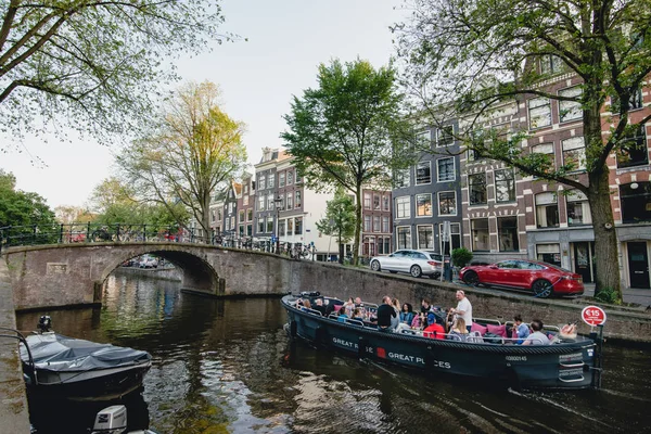 Amsterdam - Circa juni 2017: klassieke weergave een gracht en brug met traditionele Nederlandse huizen op de dijken in Amsterdam, Nederland in juni 2017. — Stockfoto