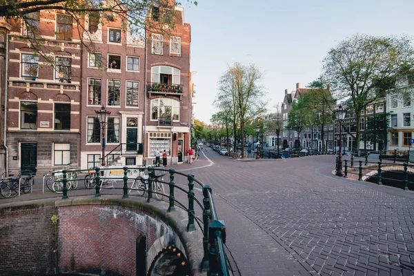 Amsterdam - Circa juni 2017: klassieke weergave een gracht en brug met traditionele Nederlandse huizen op de dijken in Amsterdam, Nederland in juni 2017. — Stockfoto