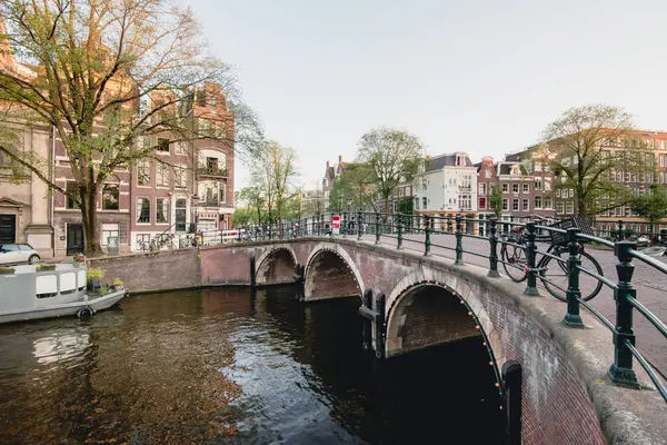AMSTERDAM - CIRCA JUNIO 2017: vista clásica de un canal y puente con casas holandesas tradicionales en los terraplenes de Ámsterdam, Holanda en junio de 2017 . —  Fotos de Stock