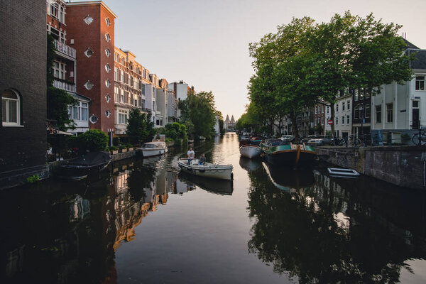 AMSTERDAM - CIRCA JUNE 2017: classic view a canal and bridge with traditional dutch houses on the embankments in Amsterdam, The Netherlands in June 2017.