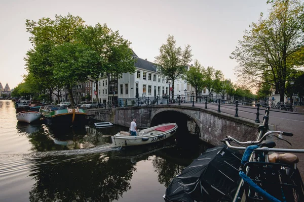 AMSTERDAM - CIRCA JUNE 2017: classic view a canal and bridge with traditional dutch houses on the embankments in Amsterdam, The Netherlands in June 2017. — Stock Photo, Image