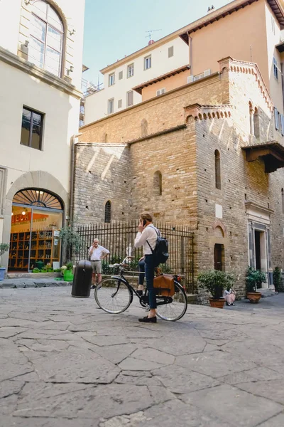 FLORENCIA, ITALIA - CIRCA JUNIO 2017: hombre con estilo en la bicicleta en el centro de la ciudad vieja con edificios florentinos antiguos en Florencia, Italia en junio 2017 . — Foto de Stock