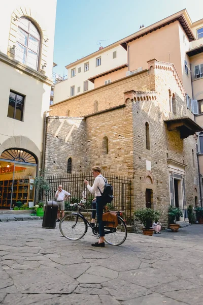 FLORENCIA, ITALIA - CIRCA JUNIO 2017: hombre con estilo en la bicicleta en el centro de la ciudad vieja con edificios florentinos antiguos en Florencia, Italia en junio 2017 . — Foto de Stock