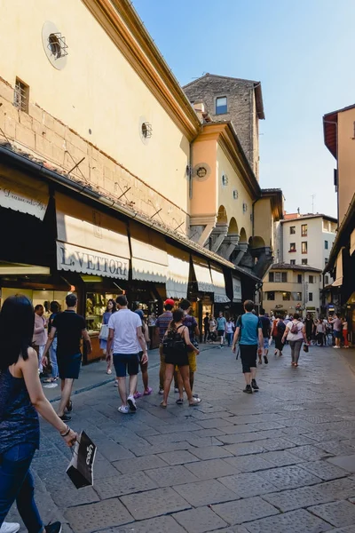 FLORENCIA, ITALIA - CIRCA JUNIO 2017: la gente camina por el Ponte Vecchio con tiendas de artesanía y joyería en Florencia, Italia en junio de 2017 . — Foto de Stock