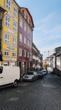 PORTO, PORTUGAL - 13 Mart 2020: Güneşli bir günde Porto 'nun tarihi merkezinde eski bir kasabada geleneksel Portekiz cephesi olan dar bir sokak.