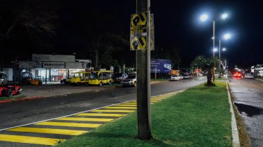 COLONIA DEL SACRAMENTO, URUGUAY - 9 Ekim 2019: Geceleyin en eski sömürge kasabası Colonia del Sacramento 'daki otobüs durağı yakınındaki yol.