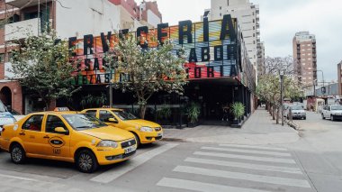 CORDOBA, ARGENTINA - CIRCA ECTOBER 2019: Popüler hippi mahallesi Barrio Guemes 'de sokakta sarı taksi.