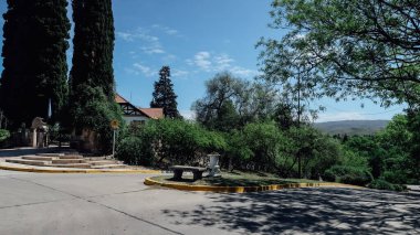 ALTA GRACIA, ARGENTINA - 31 Ekim 2019: Küçük bir kasaba olan Cordoba yakınlarındaki yeşil ağaçlar ve bitkiler mavi gökyüzü ile güneşli bir bahar günü.