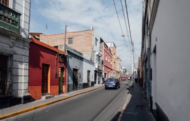 AREQUIPA, PERU - CIRCA NOVEMBER 2019: Mavi gökyüzü güneşli bir günde Arequipa 'nın merkezinde koloni binaları olan küçük dar bir sokak.