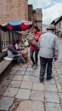 CUSCO, PERU - CIRCA NOVEMBER 2019: Eski Cusco kasabasındaki küçük bir kaldırım taşındaki insanlar ve sokak satıcıları.