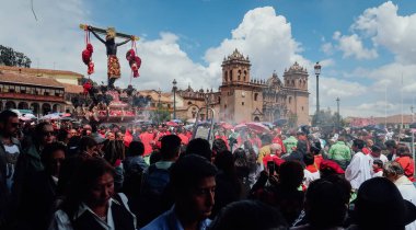 CUSCO, PERU - CIRCA NOVEMBER 2019: Eski şehir Cusco 'daki Plaza de Armas' da İsa 'nın heykelini taşıyan geleneksel geçit töreninde kırmızı pelerinli büyük bir kalabalık.