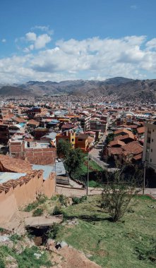 CUSCO, PERU - CIRCA NOVEMBER 2019: Dağlarla çevrili turuncu kiremitli çatıları olan eski Cusco kasabasının havadan görünüşü.