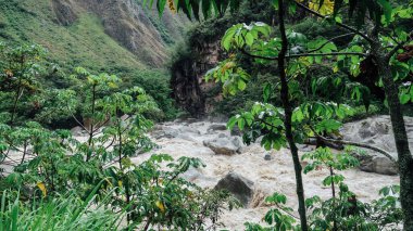 MACHU PICCHU, PERU - CIRCA Kasım 2019: Machu Picchu Pueblo 'ya giden tren yolu boyunca yeşil dağları ve hızlı nehri olan manzara.