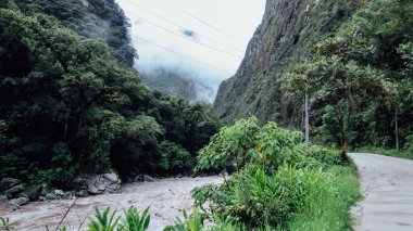 MACHU PICCHU, PERU - CIRCA Kasım 2019: Machu Picchu yolu boyunca yeşil dağlar arasındaki hızlı nehir kayıp şehir.