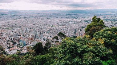 BOGOTA, COLOMBIA - CRCA Aralık 2019: Bulutlu gökyüzü ile Monserrate dağının tepesinden Bogota şehrinin havadan görünüşü.