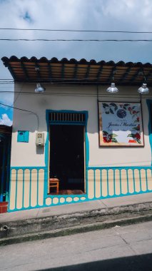 SALENTO, COLOMBIA - CIRCA JANUARY 2020: Salento 'nun merkezinde geleneksel detaylarla birlikte renkli bina cepheleriyle beyaz renklere boyanmış sokak.