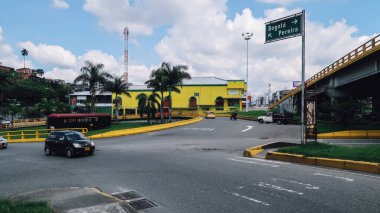 ARMENIA, COLOMBIA - CIRCA JANUARY 2020: Antioquia 'nın orta kesimindeki Ermenistan kasabasındaki yol kavşağı yakınlarındaki sarı bina ve yol işaretleri.
