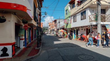 GUATAPE, COLOMBIA - CIRCA HAZİRANESİ 2020: Renkli otantik Guatape şehrinin kaldırım taşı sokağındaki geleneksel benzersiz dekore edilmiş binalar.