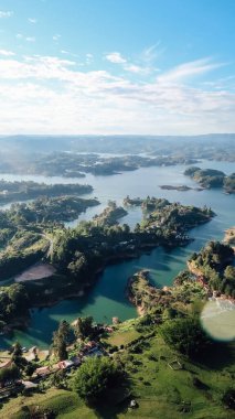 GUATAPE, COLOMBIA - CIRCA JANUARY 2020: Güneşli bir günde Guatape 'de birçok küçük ada ve mavi suyu olan ünlü yapay göllerin havadan görünüşü.