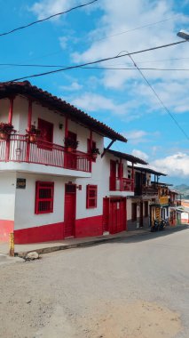 JARDIN, COLOMBIA - CIRCA JANUARY 2020: Antioquia 'nın küçük Jardin kasabasındaki renkli sokaklardaki geleneksel binaların ve balkonların parlak boyanmış kapıları.