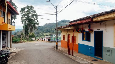 JARDIN, COLOMBIA - CIRCA JANUARY 2020: Antioquia 'nın küçük Jardin kasabasındaki renkli sokaklardaki geleneksel binaların ve balkonların parlak boyanmış kapıları.