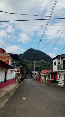 JARDIN, COLOMBIA - CIRCA JANUARY 2020: Antioquia 'nın küçük Jardin kasabasındaki renkli sokaklardaki geleneksel binaların ve balkonların parlak boyanmış kapıları.