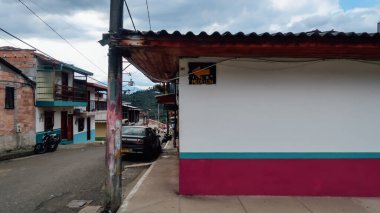JARDIN, COLOMBIA - CIRCA JANUARY 2020: Antioquia 'nın küçük Jardin kasabasındaki renkli sokaklardaki geleneksel binaların ve balkonların parlak boyanmış kapıları.