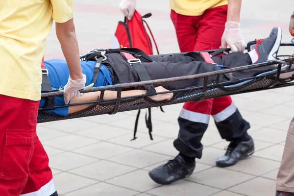 Les ambulanciers évacuent une personne blessée — Photo