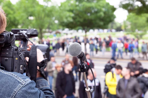 Microphone in focus, cameraman filming blurred crowd — Stock Photo, Image