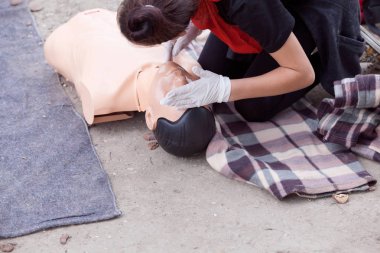 Nabız alıyorum. Kardiyopulmoner resüsitasyon - Cpr eğitim kukla gösterilen kadın sağlık görevlisi.