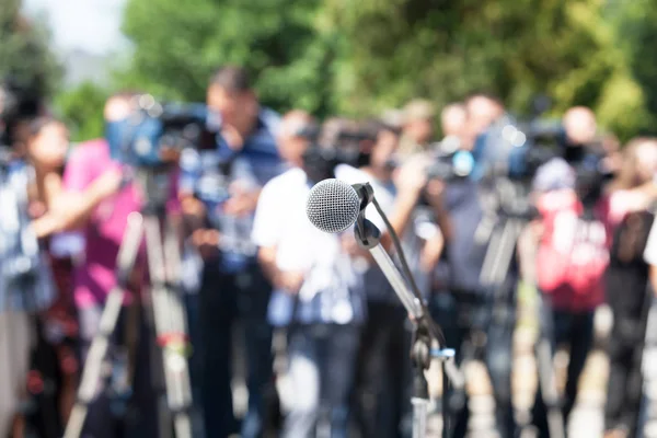 Conferência de imprensa. Microfone em foco, operadores de câmera desfocados — Fotografia de Stock