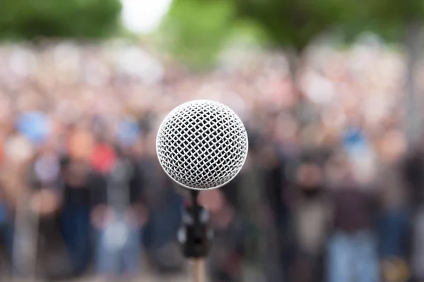 Microphone in focus against blurred crowd. Political rally. — Stock Photo, Image