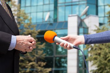 Muhabir mülakat iş adamı, arka planda bina kurumsal