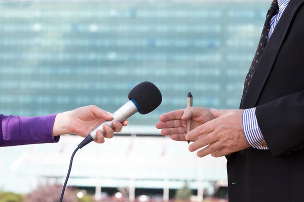 Journalist interviewt Unternehmer, Firmengebäude im Hintergrund — Stockfoto