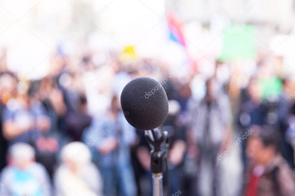 Microphone in focus, against blurred crowd