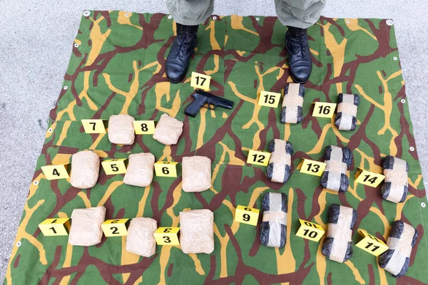 Police officer standing guard over seized packages of drug — Stock Photo, Image