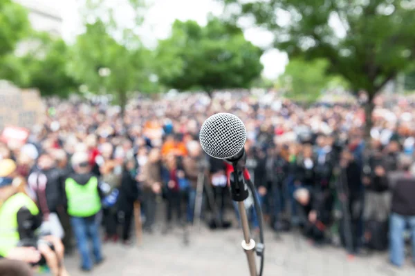 Polityczny protest. Demonstracji. Mikrofon w fokus przeciwko niewyraźne tłum. — Zdjęcie stockowe