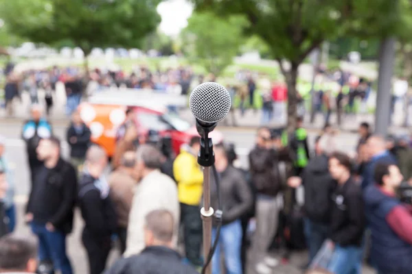 Politický protest. Demonstrace. Mikrofon v zaměření proti rozmazané dav. — Stock fotografie