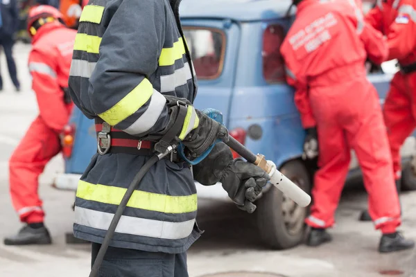 Brandmän i en räddningsaktion efter trafikolycka — Stockfoto