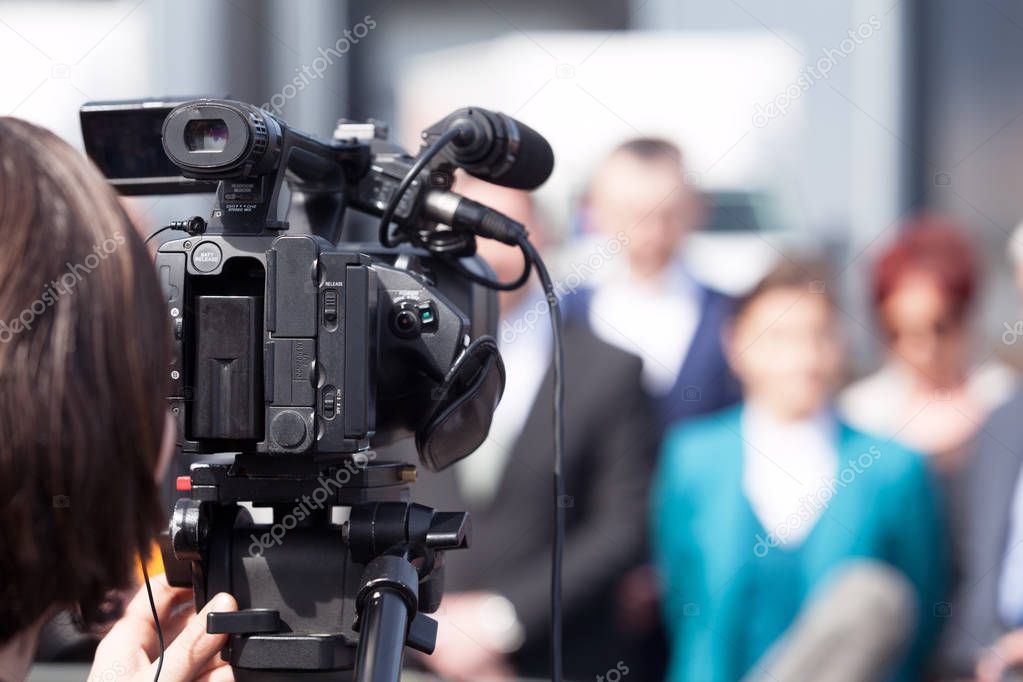 News conference. Filming an event with a video camera. Cameraman.