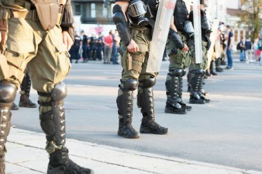 Armed riot police on duty during street protest clipart