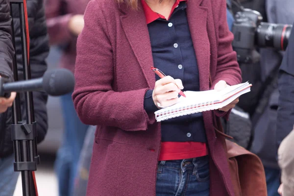 Vrouwelijke journalist op nieuwsconferentie of media-evenement, notities schrijven — Stockfoto